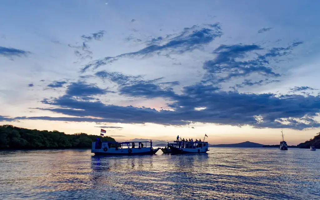 Two wooden tourist boats lying at anchor at dusk near Koabe Island, Komodo National Park.