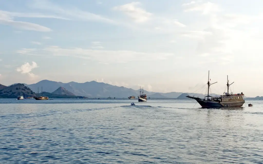 Several tourist boats anchored close together off Kelor Island, Komodo National Park.