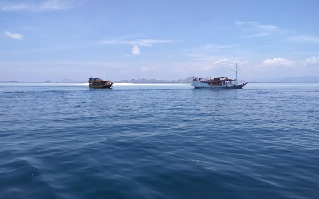 Two wooden tourist boats on open water between islands in Komodo National Park, west Flores.