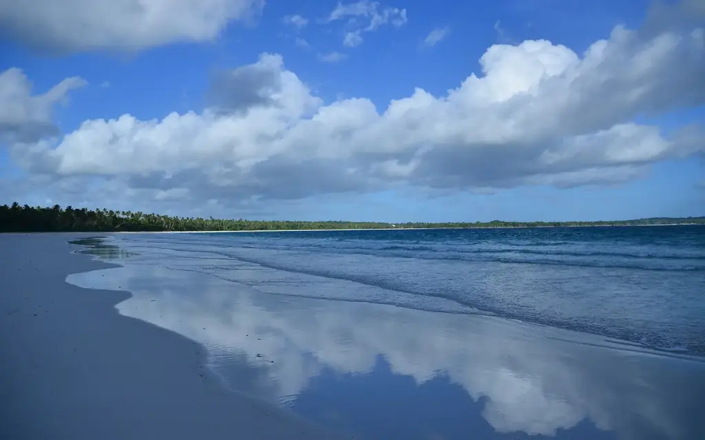 Low cloud mirrored in the wet sand of a wide, empty beach at Ngurbloat.